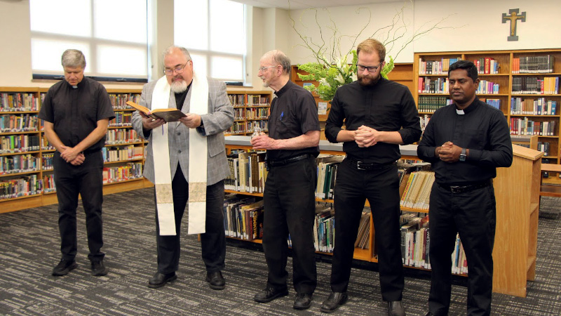 Photo of a group of priests in the library